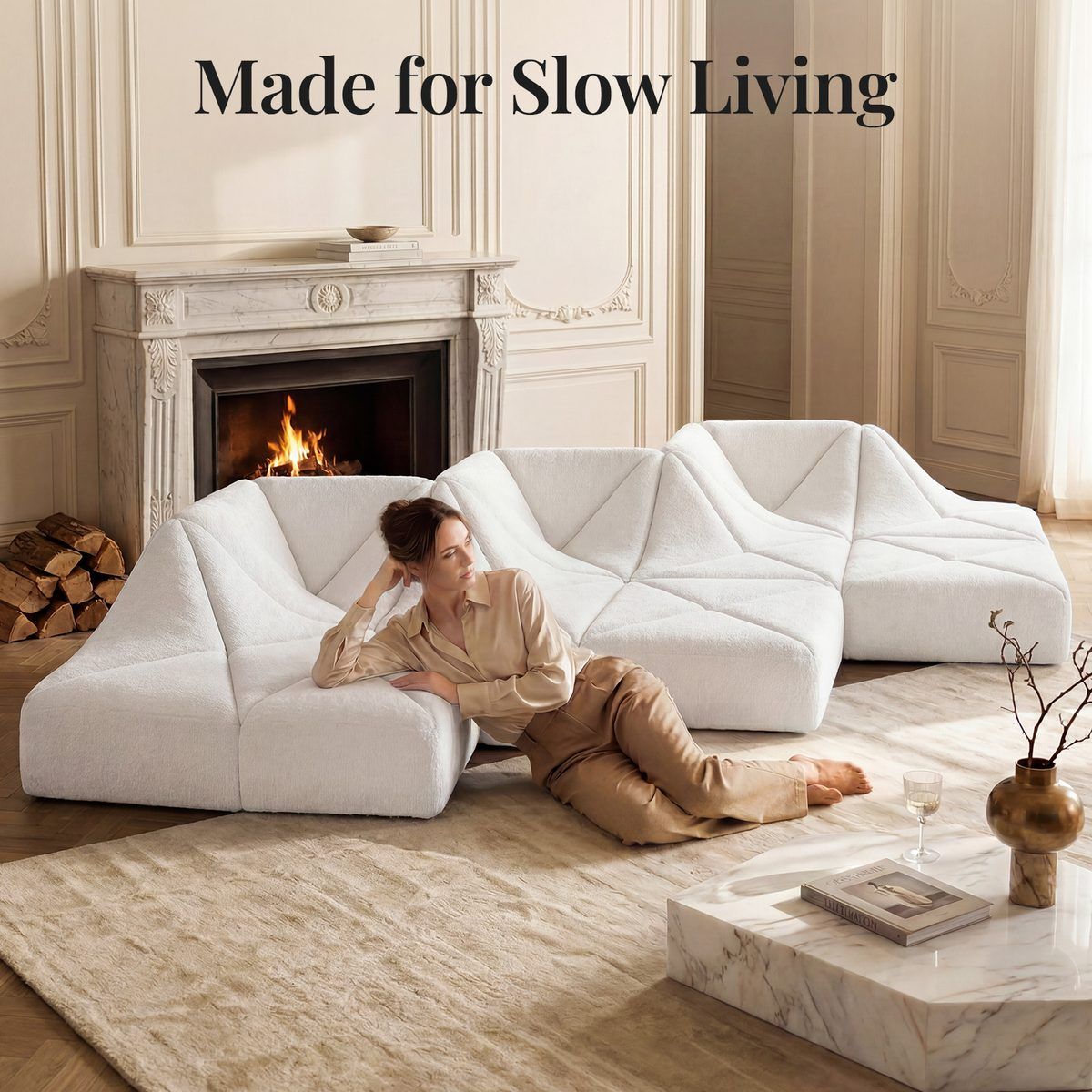 White Dune modular sofa wave layout by a marble fireplace with a woman relaxing on it