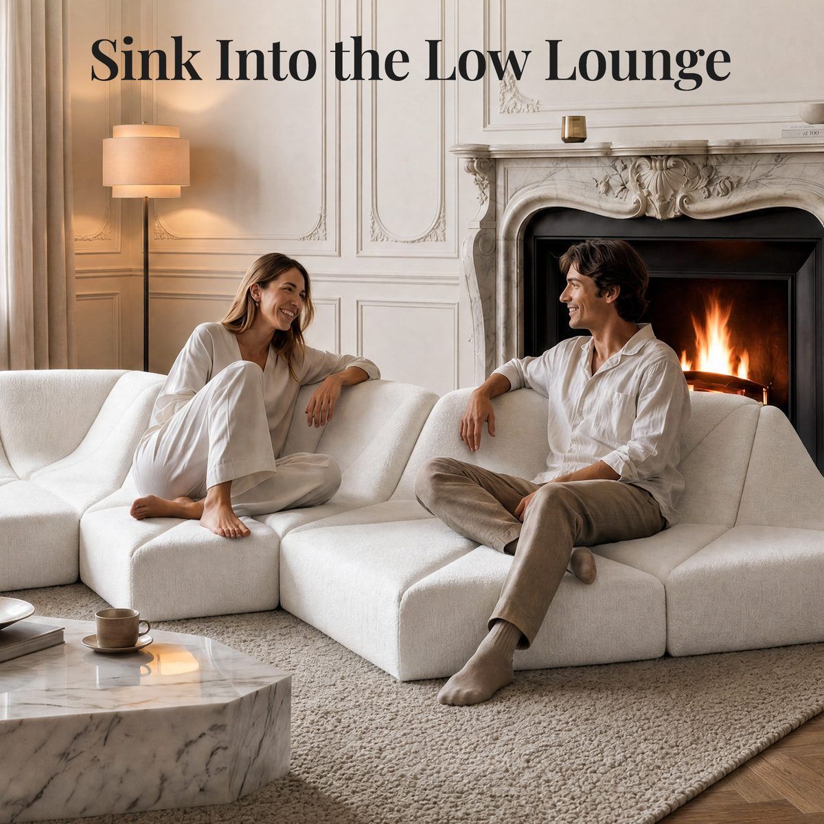 White Dune modular sofa wave layout with two people relaxing beside a fireplace