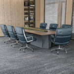 Dark Blue Eames Executive Office Chairs arranged around a wooden conference table.
