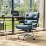 Dark Blue Eames Executive Office Chair beside a black desk and floor-to-ceiling windows overlooking a garden.