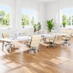 Ivory White Eames Executive Office Chairs arranged around white desks in a bright open-plan office.
