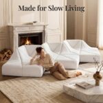 White Dune modular sofa wave layout by a marble fireplace with a woman relaxing on it