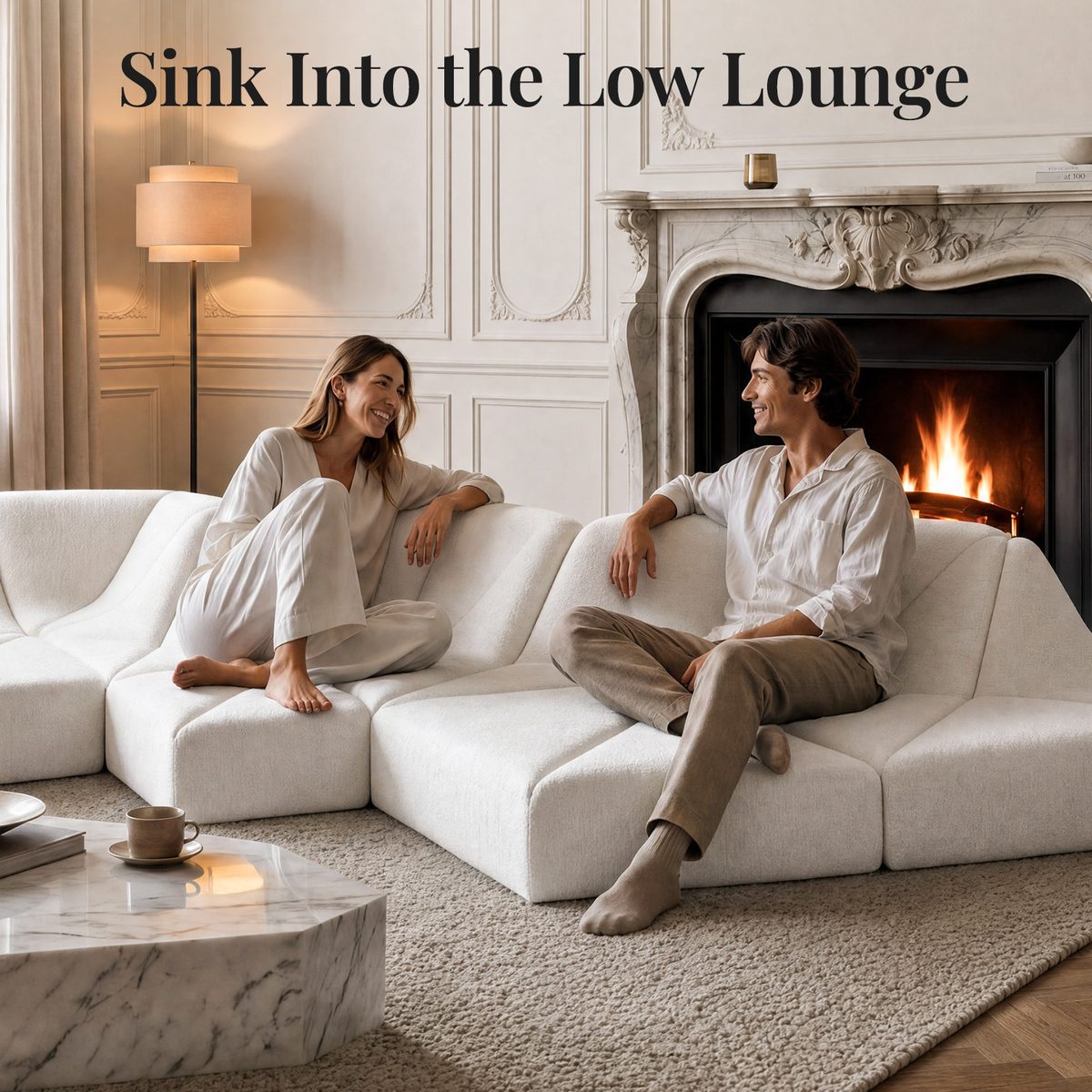 White Dune modular sofa wave layout with two people relaxing beside a fireplace